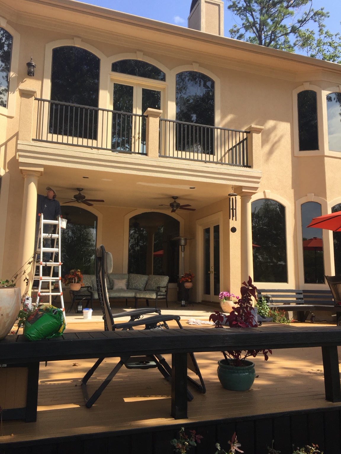 Large luxury home with ladder in place during exterior work