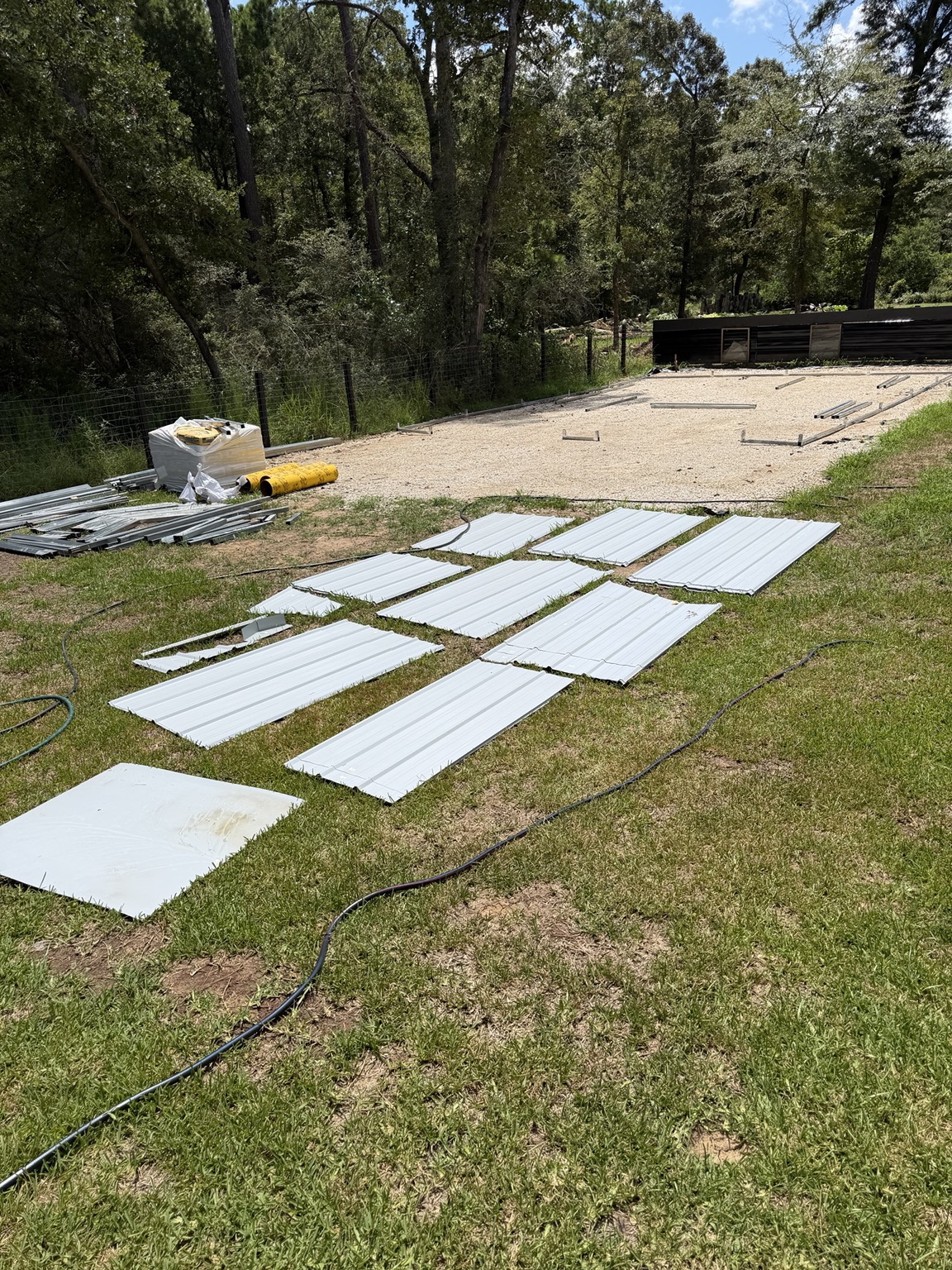 Prepared gravel building pad with metal panels staged for construction